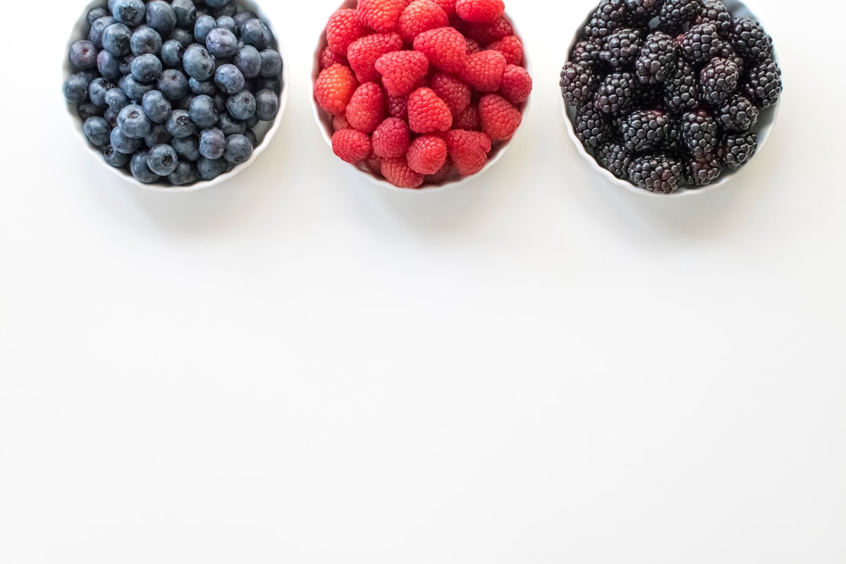 Fresh anti-inflammatory foods including salmon, berries, and leafy greens arranged on a wooden table